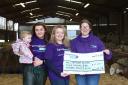 Sisters Jodie and Sophie with young niece Seren present a cheque to Laura from Lymphoma Action at the farm in Dolfor.