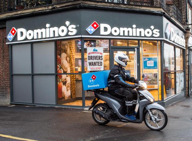 Domino's of a delivery rider outside one of their stores (PA)
