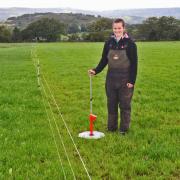 Carys Jones measures grass with a rising plate meter to inform her decision making on the grazing rotation