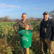 Antony Griffith (left) of Tŷ Newydd Farm, and Matt Goodall of the GWCT pictured with the feeding bucket and cover crop.